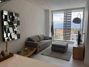 un soggiorno con divano e una grande finestra di Alojamiento sin estrés de lujo a Quito