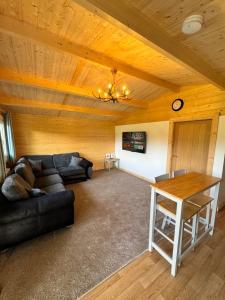 Glenariff Forest Pine Cabin في Glenariff: غرفة معيشة مع أريكة وطاولة
