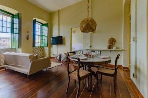 un salon avec une table et des chaises dans l'établissement Casarão de Época no Coração do Pelourinho - Studio até 6 hóspedes, à Salvador