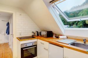 cocina con fregadero y ventana en Charmante Dachgeschosswohnung en Pforzheim