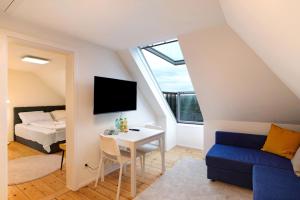 Habitación con cama, escritorio y TV. en Charmante Dachgeschosswohnung en Pforzheim