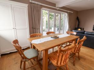 a dining room with a wooden table and chairs at Hillside House in Kelsall