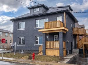 a black house with a balcony and a red fire hydrant at Brand New Home in Hamilton in Hamilton