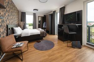 ein Hotelzimmer mit einem Bett und einem Schreibtisch in der Unterkunft We rooms Hotel in Karben