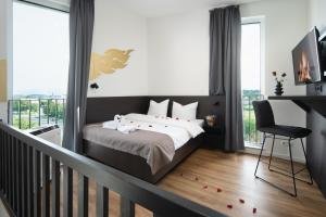 a bedroom with a bed and a balcony with windows at We rooms Hotel in Karben