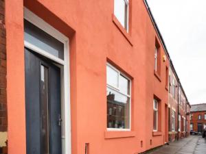 an orange building with windows on a street at Pass the Keys Beautifully refurbished home close to City in Manchester