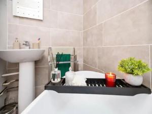 a bathroom with a sink and a bath tub at Pass the Keys Beautifully refurbished home close to City in Manchester