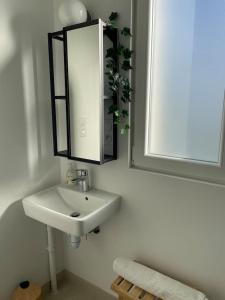 a bathroom with a sink and a mirror at Charmant Studio avec parking - Confort Moderne in Bourges