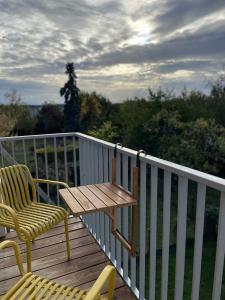 a wooden deck with a table and a chair at Charmant Studio avec parking - Confort Moderne in Bourges