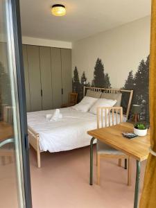 Schlafzimmer mit einem Bett und einem Holztisch in der Unterkunft Charmant Studio avec parking - Confort Moderne in Bourges