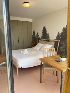 Un dormitorio con una cama y una mesa de madera. en Charmant Studio avec parking - Confort Moderne, en Bourges