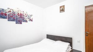 um quarto com uma cama e duas pinturas na parede em Hotel La Platouri em Voluntari