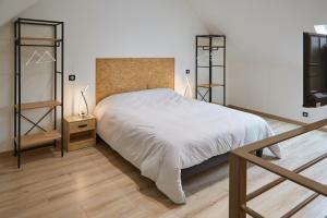 a bedroom with a white bed and a wooden floor at Paradis Champenois in Damery