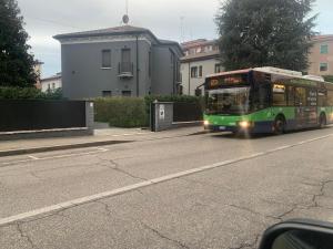 a green bus is driving down a street at Murari Brà 20 in Verona