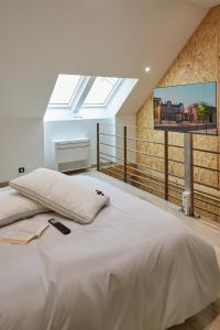 a bedroom with a large white bed with a skylight at Paradis Champenois in Damery
