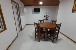 a dining room with a wooden table and chairs at Cabañas La Estación in Chascomús
