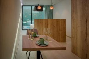 a wooden table with two glasses and a plate on it at AGORA Tournai - Wellness Suites in Tournai