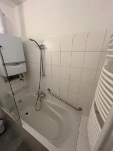 uma casa de banho com um chuveiro e uma banheira com um WC. em Stylish Youthful Condo in the Heart of Mödling, Fiatalos Boldog Otthon Mödling Szivében em Mödling