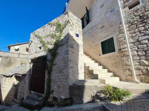 a stone building with stairs and a door at Bobelino in Povlja