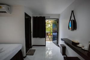 皮皮島的住宿－The Bright House, Koh Phi Phi，一间设有卧室的客房,卧室设有通往阳台的门