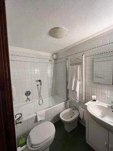 een badkamer met een toilet, een bad en een wastafel bij refuge du skieur cir 0051 in Courmayeur