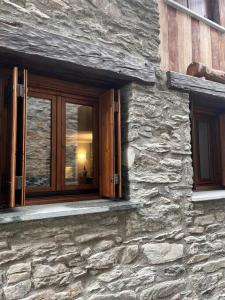 een stenen gebouw met twee ramen aan de zijkant bij refuge du skieur cir 0051 in Courmayeur