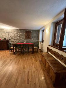 a room with a table and chairs and a wooden floor at refuge du skieur cir 0051 in Courmayeur