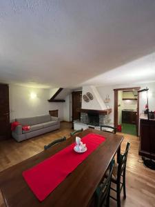 een woonkamer met een houten tafel met een rood tapijt bij refuge du skieur cir 0051 in Courmayeur