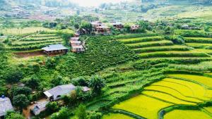 an aerial view of a village on a rice field at Na Thẩm Eco Hill Homestay - Trạm Tấu in Cham Ta Lao