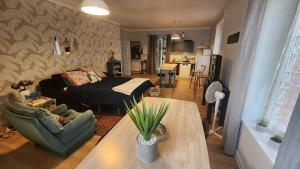 ein Wohnzimmer mit einem Sofa und einem Tisch in der Unterkunft Artistique in Sillé-le-Guillaume