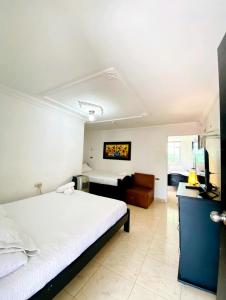 a bedroom with a large white bed and a couch at Hotel West California in Armenia