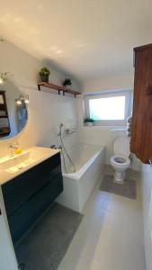 ein Badezimmer mit einer Badewanne, einem WC und einem Waschbecken in der Unterkunft Wohnung am Spitalberg in Klagenfurt am Wörthersee