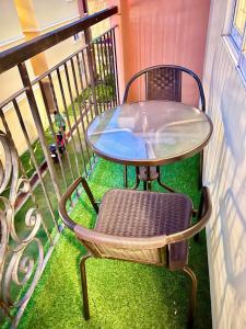 balcón con mesa de cristal y silla en AJ’s Cozy Condo Davao, en Davao City