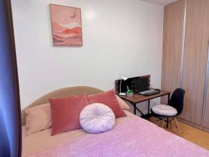 1 dormitorio con 1 cama y escritorio con ordenador en AJ’s Cozy Condo Davao, en Davao City