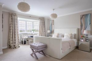 a white bedroom with a large bed and a table at Riverbank house - Cookham in Cookham