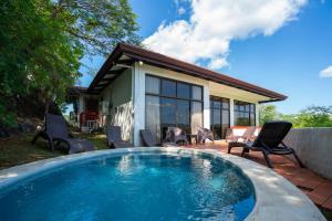 a swimming pool in front of a house at Ocean Breath Villa at Villas Sol Resort in Sardinal