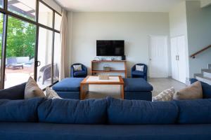 a living room with a blue couch and a table at Ocean Breath Villa at Villas Sol Resort in Sardinal