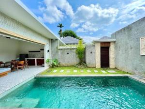 a swimming pool in the backyard of a house at Livin Sanur Villa in Denpasar