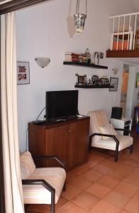 sala de estar con 2 sillas y TV de pantalla plana en Casa Linda da Praia do Alfamar, en Albufeira