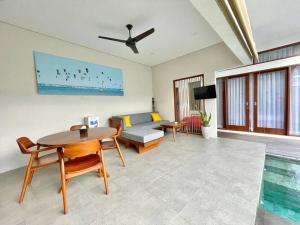 Livin Sanur Villa في دينباسار: غرفة معيشة مع طاولة وأريكة