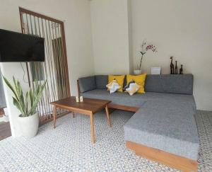Livin Sanur Villa في دينباسار: غرفة معيشة مع أريكة زرقاء وطاولة