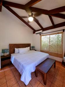 a bedroom with a large bed and a window at Casa de Encanto Tropical Villa in Playa Hermosa