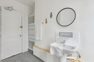 ein weißes Badezimmer mit einem Waschbecken und einem Spiegel in der Unterkunft Hôtel Juliette in Paris