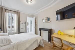 Schlafzimmer mit einem Bett, einem Schreibtisch und einem Kamin in der Unterkunft Hôtel Juliette in Paris