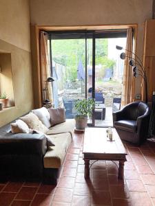 een woonkamer met een bank en een salontafel bij Maison eco-responsable proche de Paris in Villennes-sur-Seine