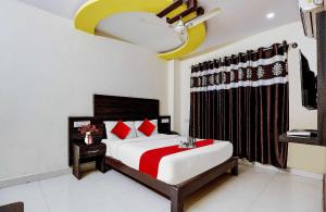 1 dormitorio con 1 cama con almohadas rojas en OYO Flagship Hmr Hotel Near Iskcon Temple Bangalore, en Bangalore