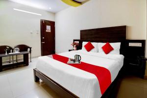 a bedroom with a large bed with red pillows at OYO Flagship Hmr Hotel Near Iskcon Temple Bangalore in Bangalore