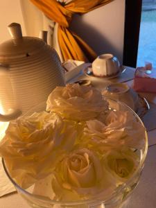 una ciotola di vetro con delle rose su un tavolo di VIENIACASACCADIA ad Accadia