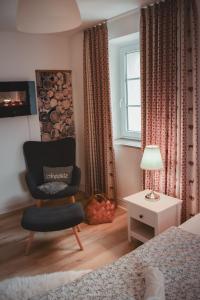 a bedroom with a chair and a window at Wohlfühl-Ferienhaus Eifel-Landurlaub mit Herz in Dahlem