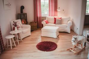 a living room with two chairs and a couch and a table at Wohlfühl-Ferienhaus Eifel-Landurlaub mit Herz in Dahlem